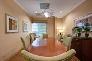 Conference room with large dining room table, buffet and yellow walls.