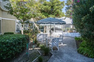 Outside courtyard with table, chairs and striped umbrella
